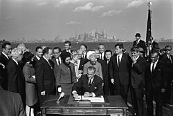 President Johnson signs the Immigration and Nationality Act of 1965 as U.S. Senators Edward Kennedy and Robert F. Kennedy, and others look on