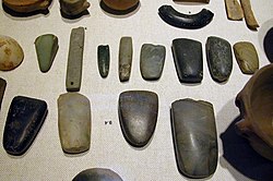 An array of Neolithic artefacts, including bracelets, axe heads, chisels, and polishing tools – Neolithic stone artefacts are by definition polished and, except for specialty items, not chipped