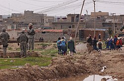 Iraqi police, U.S. soldiers patrol neighborhood in Mosul, 19 March 2007