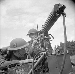 A soldier of the Manchester Regiment with the unit's fleur-de-lis cap badge on his helmet, 1941