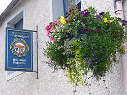An Comunn Gaidhealach & Royal National Mòd sign and hanging basket outside the main offices along Church Street, Inverness.