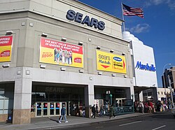 2011 photo of a Sears big box store with subway station in Rego Park, Queens, New York City, New York. This location closed in 2017 and was afterwards occupied by an IKEA store, which closed in 2022.