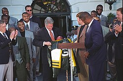 Brett Favre and Reggie White (front) present a Packers jacket to President Bill Clinton in May 1997.