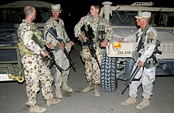 Two Royal Australian Air Force Airfield Defense Guards (at left and second from the right) with two members of the United States Air Force Security Forces at Baghdad International Airport.