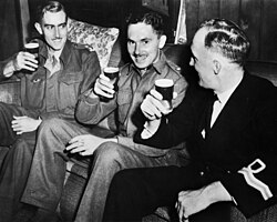 Lieutenant D. M. N. Davidson (right) of the RNVR enjoying beer with members of Z Special Unit in Brisbane after the completion of Operation Jaywick