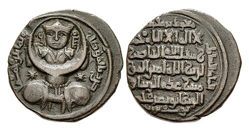Coinage of Izz ad-Din Mas'ud, Zengid ruler of Mosul, with crowned Turkic figure holding a moon symbol. Mosul mint, dated 1189–90. The reverse mentions in Arabic the name and titles of the Abbasid caliph and Abbasid heir presumptive in five lines, and the name and titles of the Ayyubid overlord Saladin, and 'Izz al-Din Mas'ud.[50][45]
