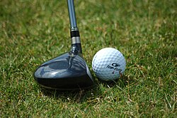 A wood positioned ready to be swung and to strike a golf ball