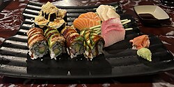 Dragon roll, uramaki with multiple fillings including crab meat, cucumber, avocado, with rice topped with eel and avocado