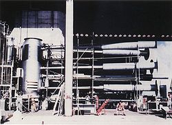 A view of the Ivy-Mike "SAUSAGE" device; the world's first ever fully-fledged thermonuclear device, with its instrumentation and cryogenic equipment attached. The long pipes were for measurement purposes; their function was to transmit the first radiation from the "primary" and "secondary" stages (known as "Teller light") to instruments just as the device was detonated, before being destroyed in the explosion. The man seated lower right shows scale.