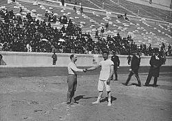 Carl Schuhmann (left) and Georgios Tsitas shake hands before the final match of the wrestling competition