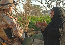 A woman pleads with an Iraqi army soldier from 2nd Company, 5th Brigade, 2nd Iraqi Army Division to let a suspected insurgent free during a raid near Tafaria, Iraq
