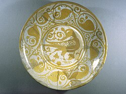 Lustreware Plate with Bird Motif, 11th century. Archaeological digs have found many kilns and ceramic fragments in al-Fustat, and it was likely an important production location for Islamic ceramics during the Fatimid period.[226]