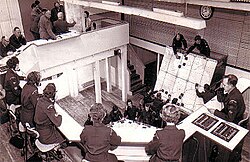 A Centre 'Ops Room': Tellers on a balcony above a plotting table and long-range handover board. A Leading Observer acts as Post Controller.
