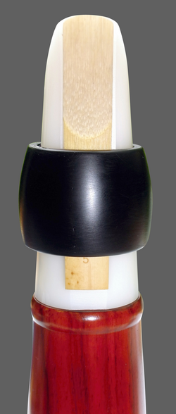 Mouthpiece with conical ring ligature, made from hard rubber, holding the reed in place