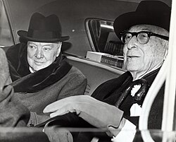 Winston Churchill and Bernard Baruch converse in the back seat of a car in front of Baruch's home.