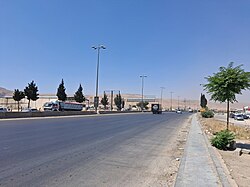 The northern entrance from M45 motorway to Damascus. The motorway has eight lanes divided by Jersey barrier and streetlight poles with four light heads each pole.
