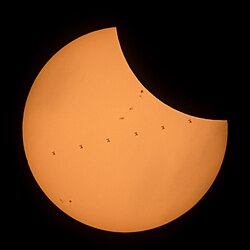 A composite image showing the ISS transit of the Sun while the 2017 solar eclipse was in progress