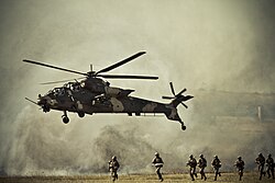 South African Army soldiers on manoeuvre with a locally developed Denel Rooivalk attack helicopter operated by the South African Air Force