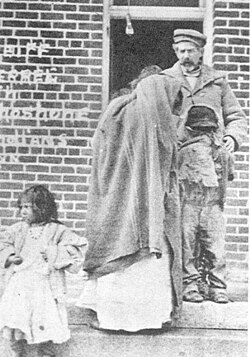 Sheriff Charles Ferrel with the surviving members of Mike Daggett's family (Daggett's daughter Heney (Louise, 17), and two of his grandchildren, Cleveland (Mosho, 8), and Hattie (Harriet Mosho, 4))