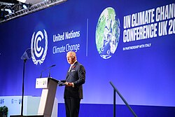 Charles delivers a speech at a podium with a backdrop with the logo of COP 26 and United Nations Climate Change
