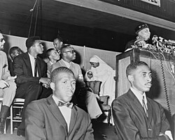 Ali (seated) at an address by Elijah Muhammad in 1964