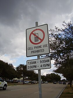 A sign in the US restricting cell phone use to certain times of day (no cell phone use between 7:30–9:00 am and 2:00–4:15 pm)