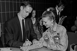 Waters signing a fan's jean jacket sleeve at the Massachusetts College of Art in Boston, 1990