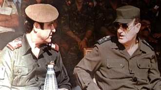 Hafez al-Assad (r) with his brother Rifaat al-Assad during a military ceremony in Damascus, 1984. Rifaat launched a failed coup attempt the same year, resulting in his expulsion from Syria.