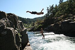 Man and woman jumping off a cliff at Colliding Rivers, Glide, Oregon