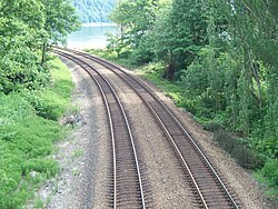 A double-track railway line running through a wooded area