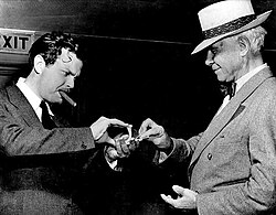 Welles performs a card trick for Carl Sandburg before the War Bond drive broadcast I Pledge America (August 1942).