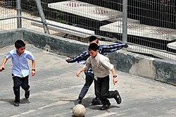 Jewish boys wearing tzitzit and kippot play soccer in Jerusalem