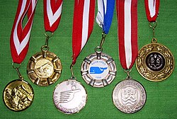 Various prize medals with obverse designs, suspension rings and ribbons typical of medals intended to be draped over the head and hung from the neck