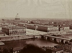 A view of Turin in the late 19th century. In the background, the Mole Antonelliana is under construction.