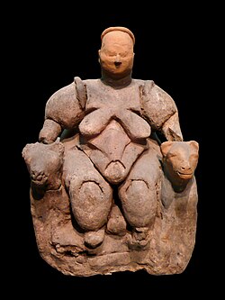 Statuette of a nude, corpulent, seated woman flanked by two felines from Çatalhöyük, dating to c. 6000 BCE, thought by most archaeologists to represent a goddess of some kind[76][77]