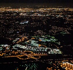 Night aerial view of the three-leaf cloverleaf interchange with Route 38, with the Delaware River and Philadelphia in the background and the New Jersey Turnpike in the foreground.