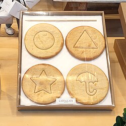 Shapes punched into dalgona, a Korean sugar candy treat, based on the shapes used in the second game of the show. Within the show, players had to extract the inner shapes intact.