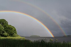 Double rainbow with Alexander's band (a dark region) visible between the primary and secondary bows. Also note the pronounced supernumerary bows inside the primary bow.