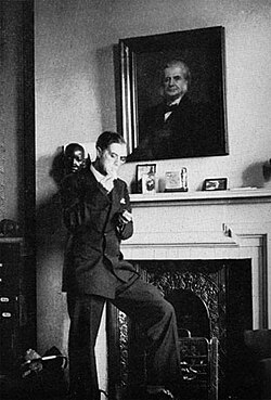 Huxley lights a cigarette under his grandfather's portrait, c. 1935.