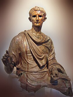 A fragment of a Roman bronze sculpture depicting Augustus wearing a toga