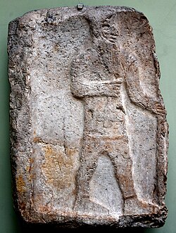 Limestone relief; stele. This unusual stele depicts an unidentified Aramaean king holding a tulip in one hand while grasping a staff or a spear in the other hand. 11th century BC. From Tell es-Salihiyeh, Damascus