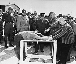 Survivors of the Ohrdruf concentration camp demonstrate torture methods used in the camp