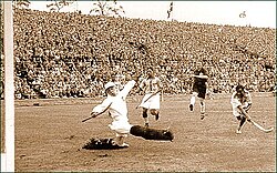 Indian player Dhyan Chand won Olympic gold medals for his team in 1928, 1932 and 1936.[23] Photo shows him scoring a goal against Germany in the 1936 Olympics hockey final.