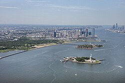 Aerial photograph of Liberty and Ellis Island in 2018. Jersey City is in the background.