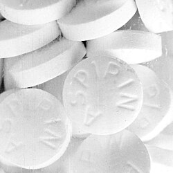 Uncoated aspirin tablets, consisting of about 90% acetylsalicylic acid, along with a minor amount of inert fillers and binders. Aspirin is a pharmaceutical drug often used to treat pain, fever, and inflammation.