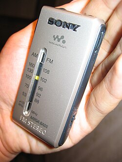 A portable battery-powered AM/FM broadcast receiver, used to listen to audio broadcast by local radio stations.