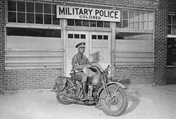 A Black military policeman in front of a "colored" entrance in Columbus, Georgia, 1942