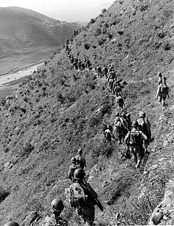 US Marines move out over rugged mountain terrain while closing with North Korean forces