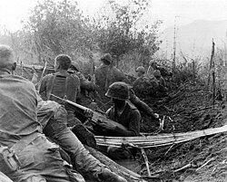 Men of the 1st Brigade, 101st Airborne Division, fire from old Viet Cong trenches during the Vietnam War.