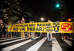 Protesters on the streets of Rio de Janeiro. Their sign translates to "If the bus fare doesn't drop, Rio is going to stop!"